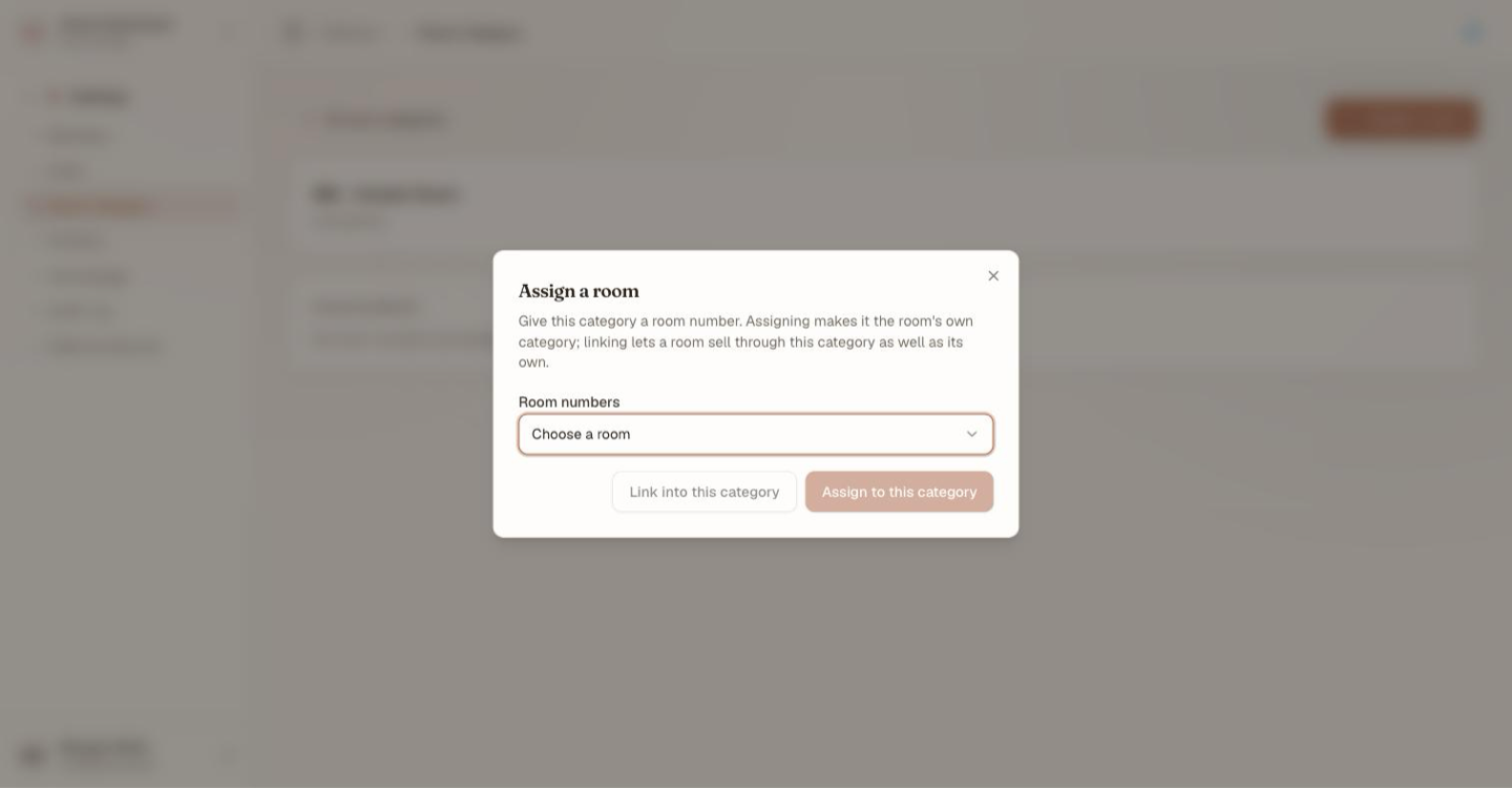 The Assign a room dialog, explaining that assigning makes the category the room's own category while linking lets a room sell through this category as well as its own